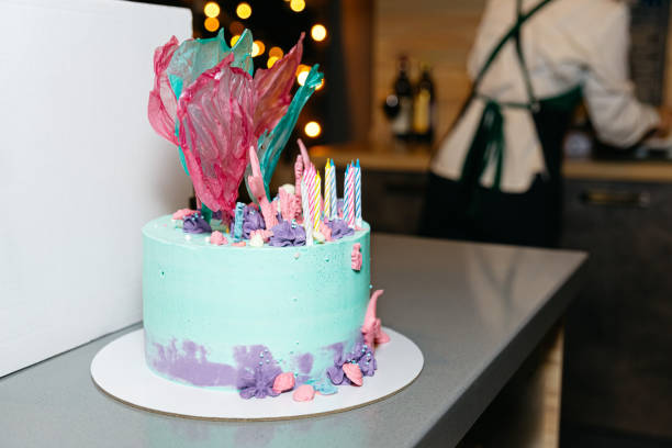 An exquisite birthday cake adorned with vibrant edible decorations and candles, ready for celebration