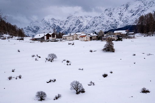 View of the beautiful winter sports resort Bos-Cha in Engadine in winter surrounded by snow-capped Swiss mountains