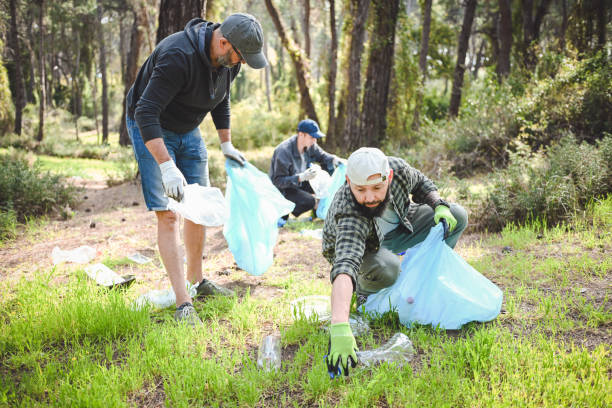 istock male volunteers collecting garbage in the forest 2055816679