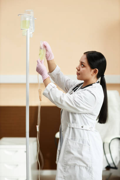 istock Doctor Setting Up Equipment for IV Drip Treatment 2055817206