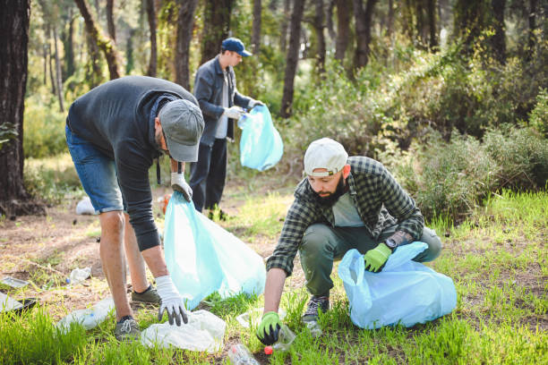 istock male volunteers collecting garbage in the forest 2055821017