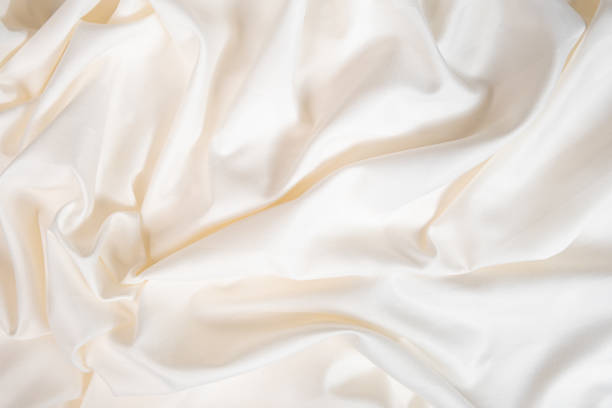 istock Waves and patterns of crumpled natural satin white milk color fabric. 2055824676