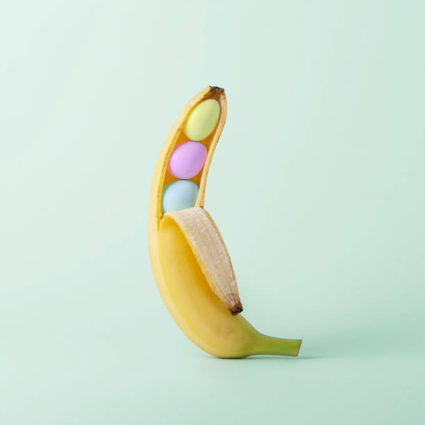 istock Creative Easter concept. Opened banana with colorful Easter eggs on green pastel background with copy space. 2055830530