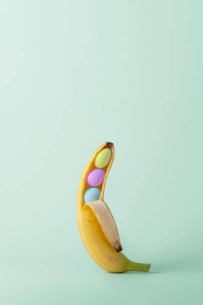 istock Creative Easter concept. Opened banana with colorful Easter eggs on green pastel background with copy space. 2055830970