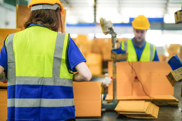 istock Warehouse worker folding paper box for packing the items in a large warehouse. man sealing cardboard boxes for shipping in cargo product stock. 2055840974
