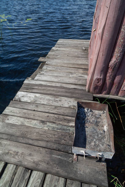 istock Metal brazier on wooden platform above  river 2055842032