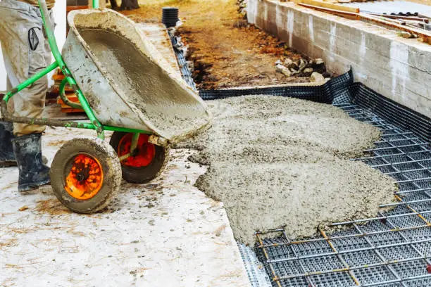 Photo of Cementing garden paths on top of metal mesh, construction work in the garden.