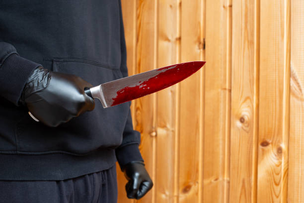 istock Killer in black gloves with bloody knife 2055877589