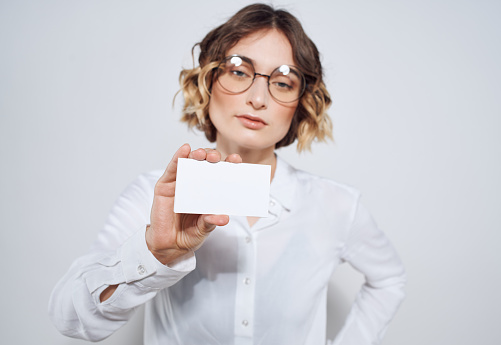 Young business lady with glasses and office outfit in her 20-30 years holding a notebook and looking at the camera - close-up