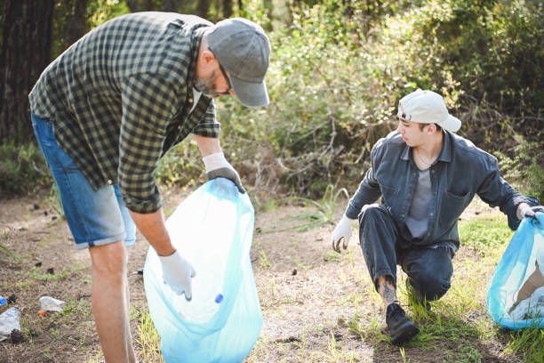 istock male volunteers collecting garbage in the forest 2055895543