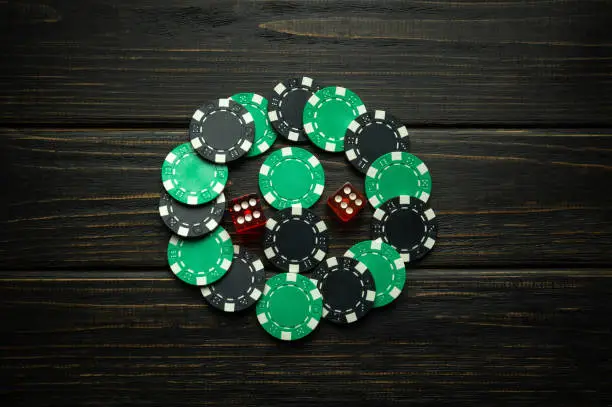 Photo of Green and black chips from a successful combination in a game of dice or craps. Low key concept of a gambling and popular game