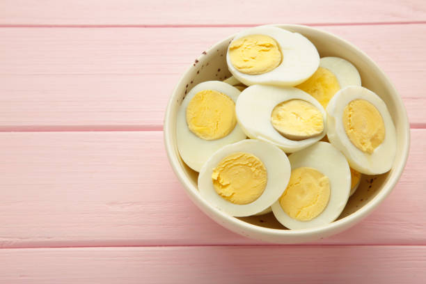 istock Boiled eggs in white ceramic plate on pink background. Space for text 2055943347