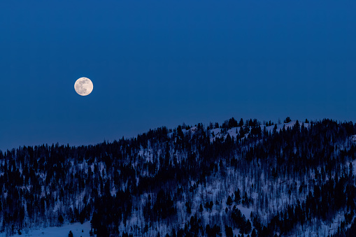 Snow Moon full over winter wilderness in Idaho