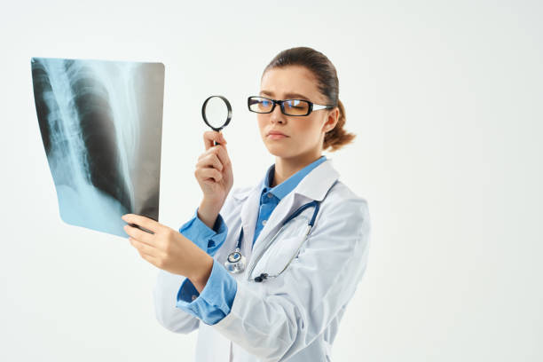 istock a nurse in a white coat looks through a magnifying glass at an x-ray 2055962273