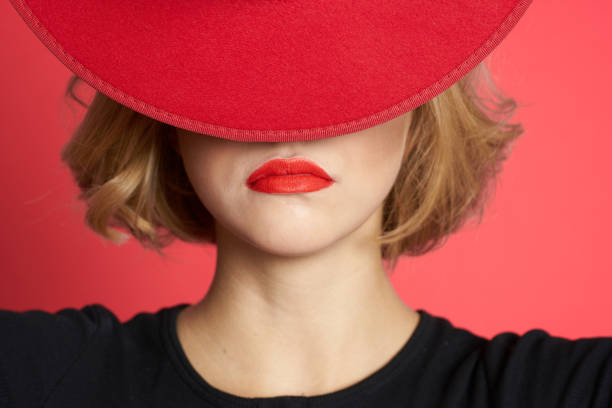istock Woman covers with hat her eyes red lips close-up isolated background 2055973278