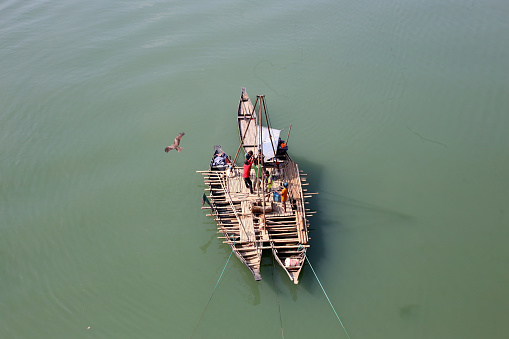 With the help of small wooden boats, the workers are working with engineers to check the soil under the river. Sylhet, Bangladesh, 4 January 2024.