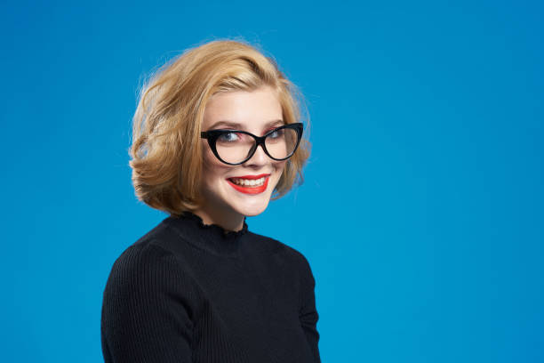 istock Blonde with short hair red lips glasses black jacket blue isolated background 2055990030