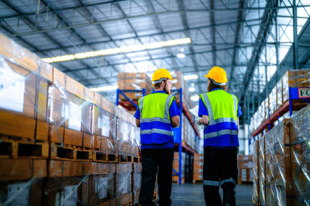 istock workers using Laser Barcode Scanner to checking stock items for shipping. male and female inspecting the store factory. industry factory warehouse. Logistics employees working at warehouse management. 2056038555