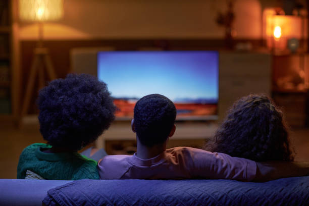 istock Back view of three people watching TV 2056047206
