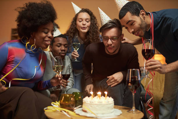 istock Man Using Wheelchair and Blowing Candles on Birthday Cake 2056047465