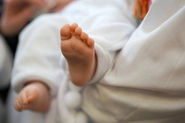 During the rite of baptism, the newborn is held barefoot.