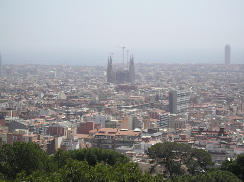 This photo shows the Sagrada Familia church in Barcelona, Spain, in 2006. The church is still under construction, but the main facade and the Nativity facade are already completed. The photo is taken from a high angle, providing a panoramic view of the church and the surrounding cityscape.