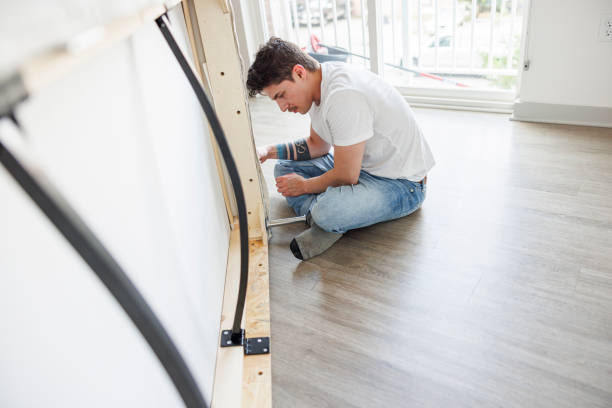 istock Young Navy officer assembling a bed on the floor in a bright apartment 2056103089