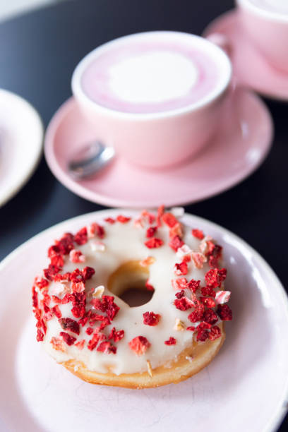 Donuts on a pink plate with pink coffee.