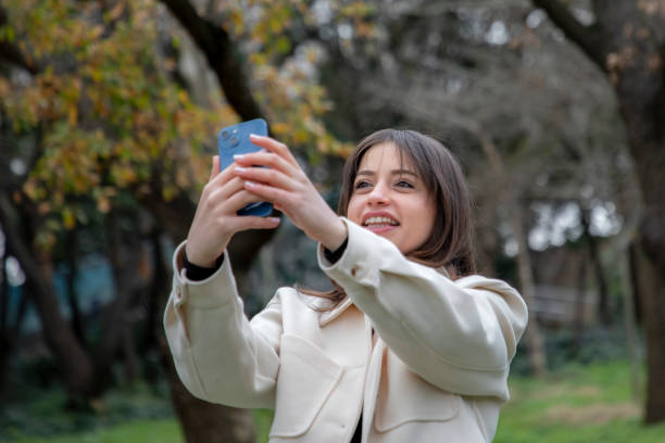 istock A beautiful woman taking a selfie in a public park 2056172827