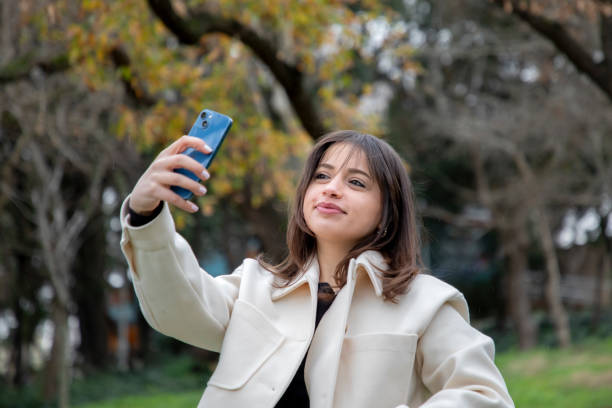 istock A beautiful woman taking a selfie in a public park 2056175936