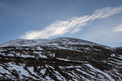 Detail of a volcanic mountain. with little snow. Blue sky with white cloud. Vikurskard, North-West Iceland.