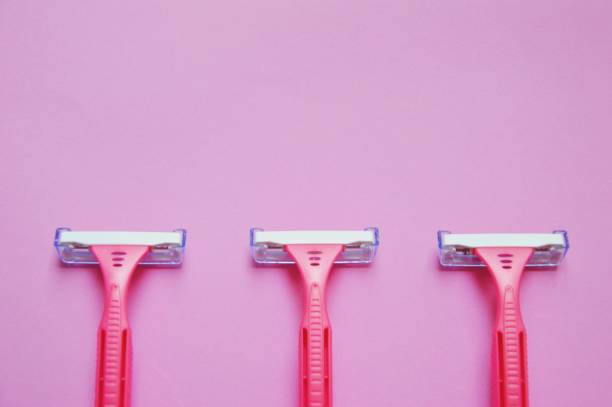 istock Overhead of pink razors on pink background 2056215861