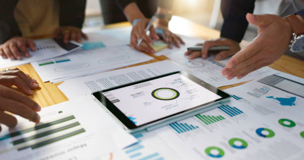 istock People, data analysis with tablet and documents, hands with online review in business meeting and team with market research. Statistics, analytics dashboard and digital infographic with collaboration 2056252960