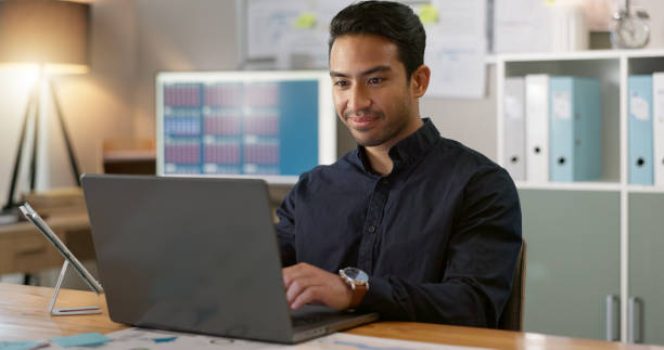 istock Happy man in office, typing on laptop and planning online research for creative project at professional digital agency. Internet, website and networking, businessman with smile and computer for email 2056259331