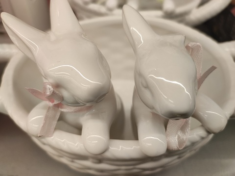 Couple of white porcelain bunnies in cup, home decoration