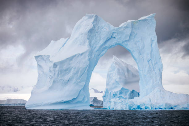 istock Antarctic landscape framed by an arch in an iceberg. 2056328115