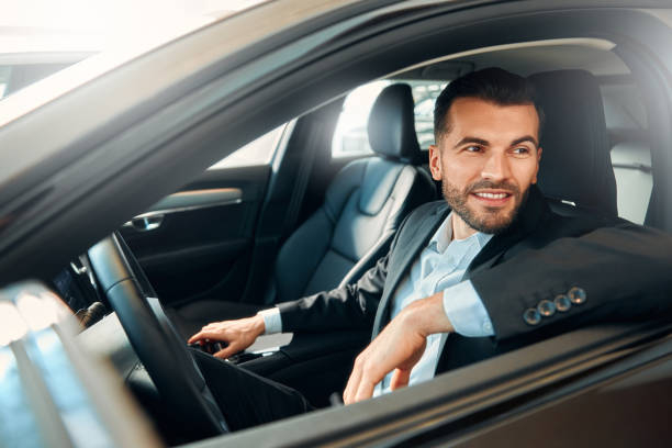 istock Businessman in a black suit in a car. 2056335727