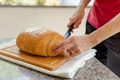 Freshly baked homemade bread being sliced to be served at breakfast. Typical homemade bread made in the Brazilian countryside