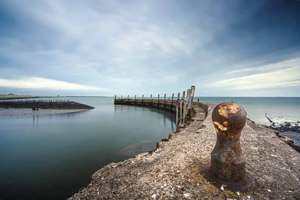 Rusted bollard on a ship mooring with a round concrete pier and a view over the sea and the cloudy sky
Flaauwers Haven, Moriaanshoofd, Schouwen Duiveland, Oosterschelde, Zeeland, Netherlands, Europe
