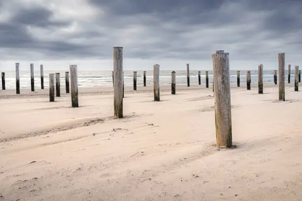Monument on the beach of Petten (Netherlands) in memory a historic flooding.Long exposure photo with sea waves stormy clouds
