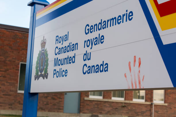 Photo of a Royal Canadian Mounted Police sign in English and French with a red colored handprint on it stock photo