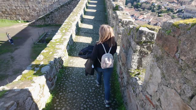 Tourist woman descending the stairs of the wall of the medieval city of Trujillo, Extremadura.