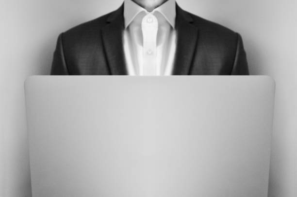 Midsection of a businessman in suit using his laptop at work