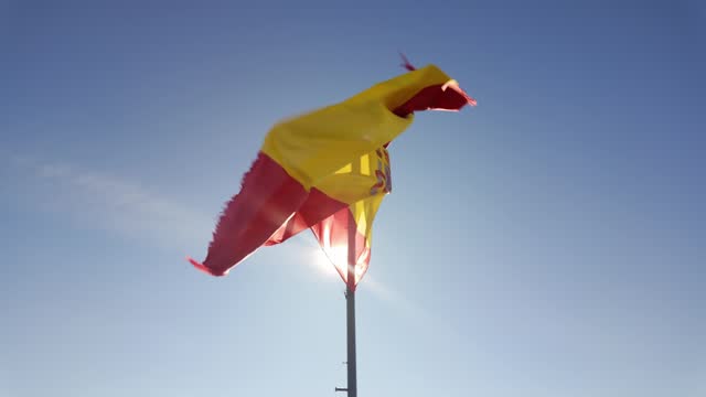 Flag of Spain waving in the wind with rays of the sun appearing according to the movement, Trujillo.