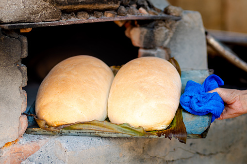 Freshly baked homemade bread in a rustic wood-fired oven. The image depicts the traditional homemade bread made in the Brazilian countryside