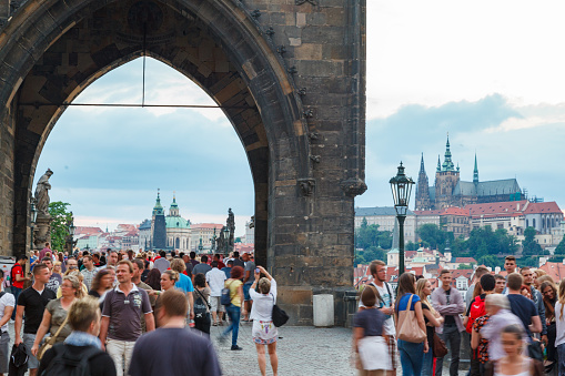 Crowd of tourists on the Old Town Bridge Tower on the famous Charles Bridge (Karluv most) and the St Vitus Cathedral, Prague, Czech Republic