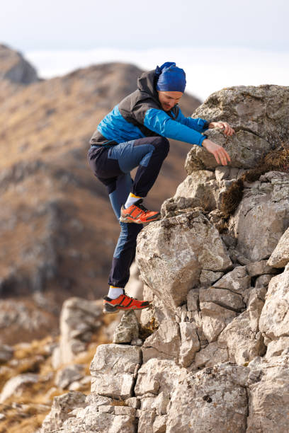 istock Young male hiker climbing the stony mountain 2056422013