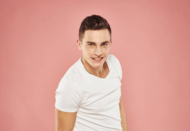istock Handsome man in white t-shirt gesturing with hands studio pink background 2056452103