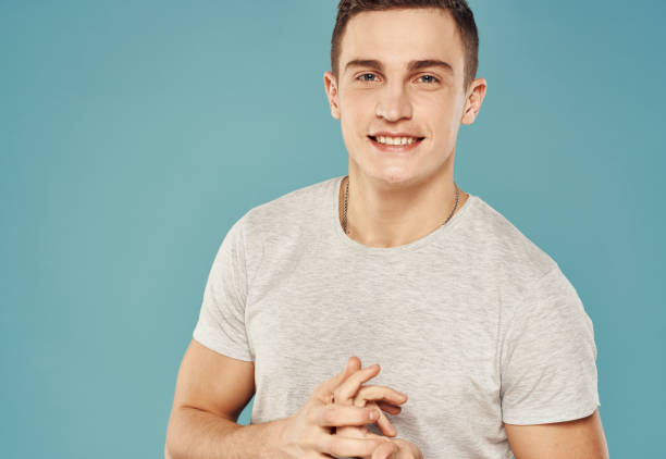 istock Cheerful handsome man in a white t-shirt studio blue background 2056466459