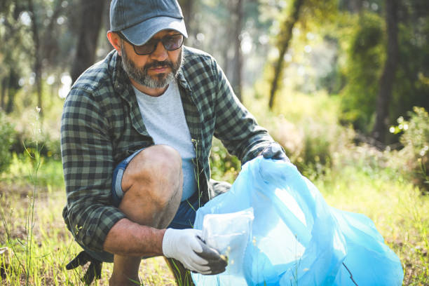 male volunteer collecting garbage in the forest